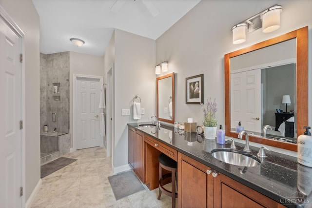 full bath with a sink, baseboards, a stall shower, and double vanity