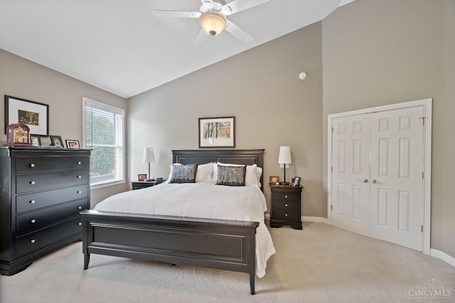 bedroom featuring baseboards, ceiling fan, a closet, and light colored carpet