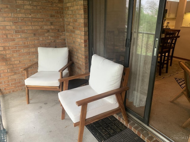 living area featuring brick wall