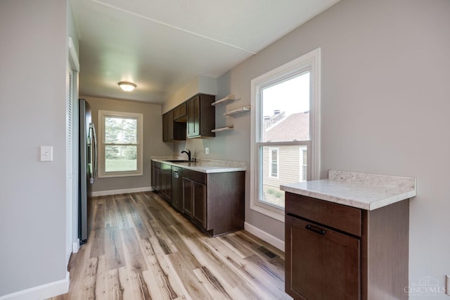 5172 Sheits Rd, Colerain Twp, OH 45251 - kitchen featuring a sink, stainless steel fridge with ice dispenser, light countertops, light wood finished floors, and dark brown cabinets