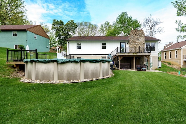 5172 Sheits Rd, Colerain Twp, OH 45251 - rear view of house featuring a wooden deck, stairs, a lawn, a chimney, and a covered pool