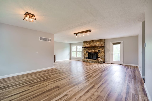 5172 Sheits Rd, Colerain Twp, OH 45251 - unfurnished living room featuring wood finished floors, a textured ceiling, baseboards, a fireplace, and rail lighting