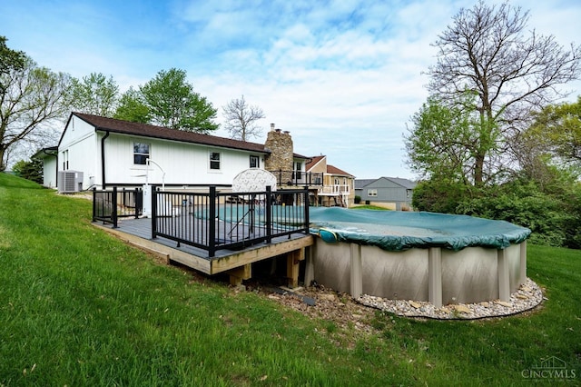 5172 Sheits Rd, Colerain Twp, OH 45251 - back of property with central AC, a wooden deck, a covered pool, a chimney, and a yard