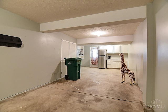 4291 Straight Arrow Rd, Beavercreek, OH 45430 - kitchen with freestanding refrigerator, white cabinets, unfinished concrete floors, and a textured ceiling