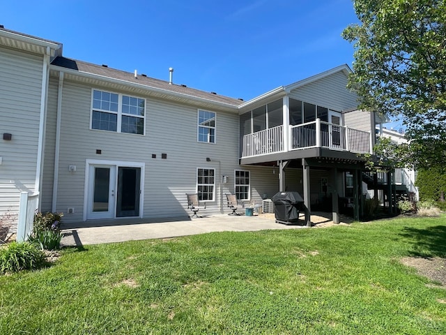 rear view of house featuring a sunroom, a yard, a patio area, and a deck