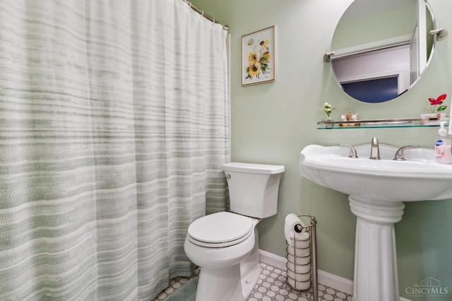 bathroom featuring a sink, baseboards, and toilet