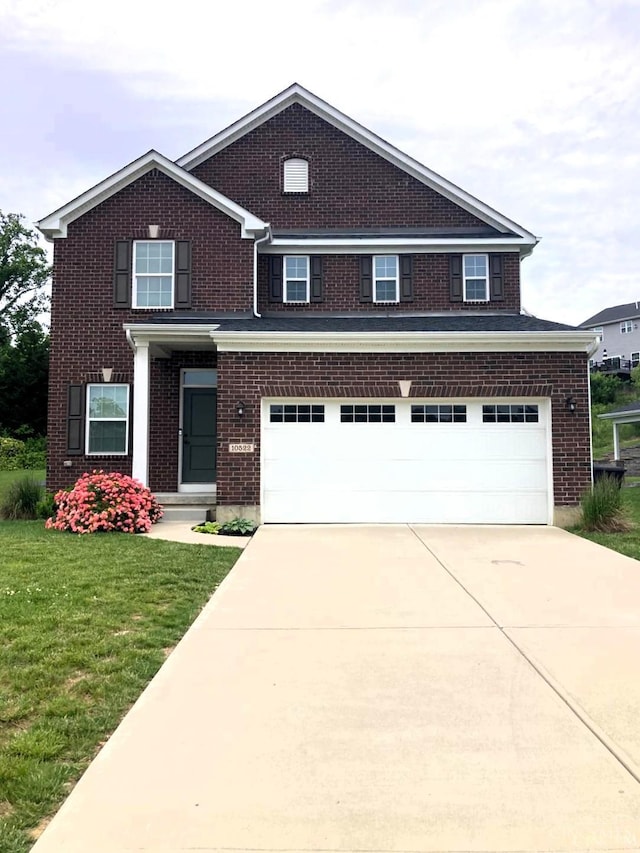 10522 Atterbury Dr, Crosby Twp, OH 45030 - view of front facade featuring an attached garage, driveway, a front yard, and brick siding