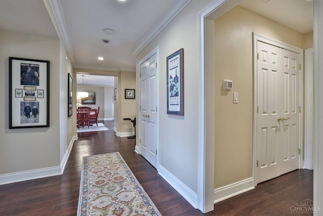 corridor featuring crown molding, dark wood finished floors, baseboards, and recessed lighting