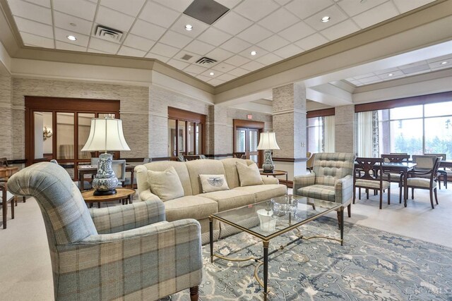 carpeted living area with ornate columns