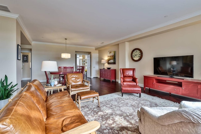 living room with wood finished floors, ornamental molding, and baseboards