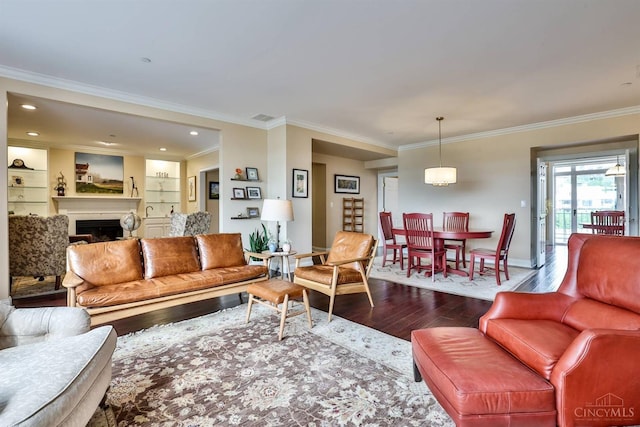 living room with dark wood finished floors, baseboards, crown molding, and a fireplace