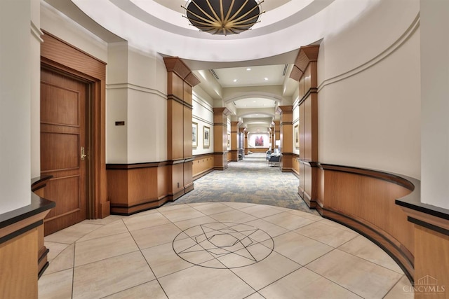 hall featuring decorative columns, light colored carpet, light tile patterned floors, recessed lighting, and wainscoting