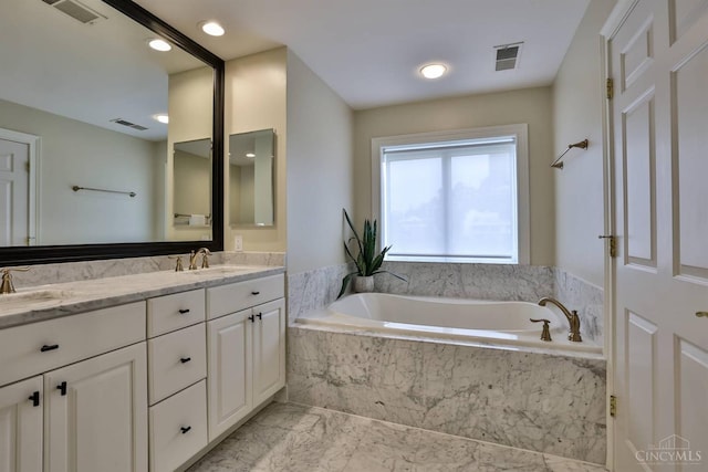 full bath featuring marble finish floors, a garden tub, and double vanity