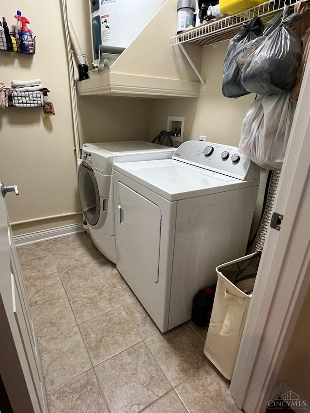 clothes washing area featuring light tile patterned floors, baseboards, laundry area, and independent washer and dryer