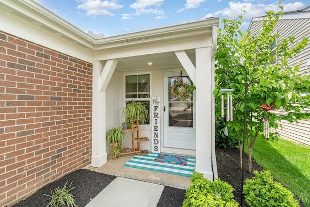 view of exterior entry featuring brick siding