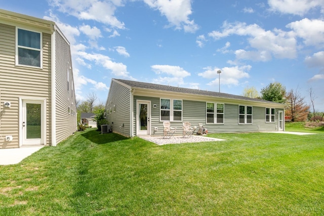 back of property with a yard, central air condition unit, and a patio