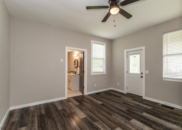 interior space featuring a ceiling fan, dark wood-type flooring, baseboards, and visible vents