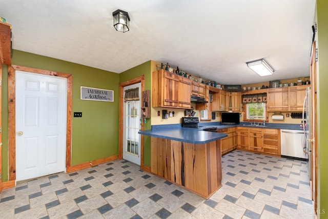 kitchen with a peninsula, a sink, dark countertops, black range with electric stovetop, and stainless steel dishwasher