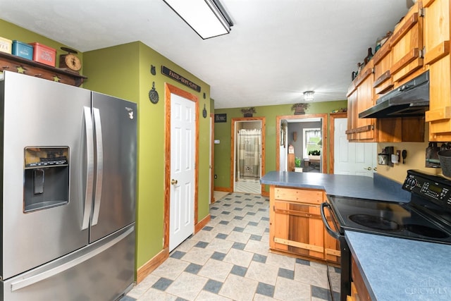 kitchen featuring light floors, under cabinet range hood, stainless steel fridge, dark countertops, and electric range