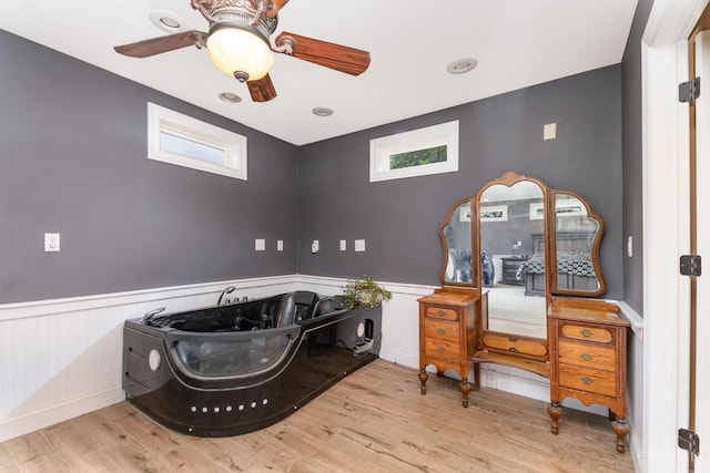 bedroom featuring a wainscoted wall, wood finished floors, and ceiling fan
