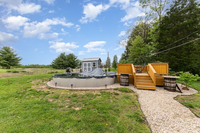 view of yard with a covered pool, a deck, a shed, and an outdoor structure