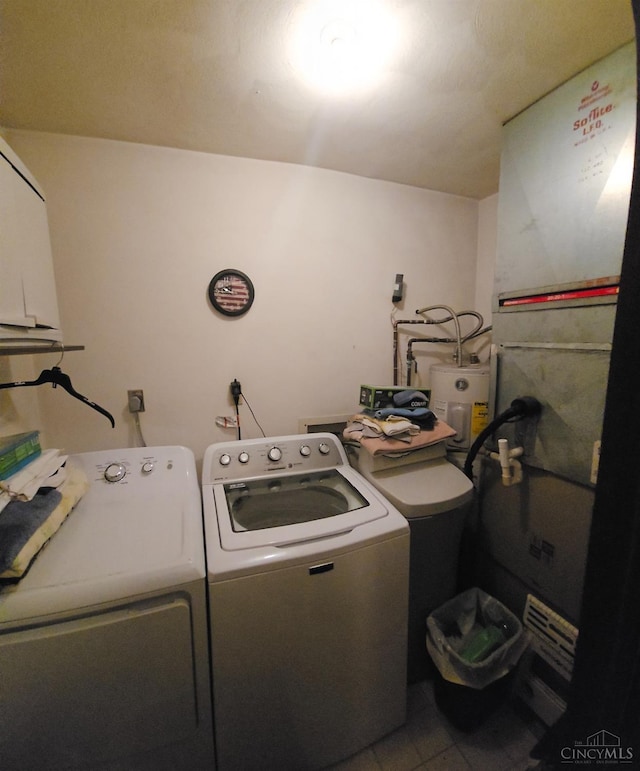 washroom featuring laundry area, washer and clothes dryer, and water heater
