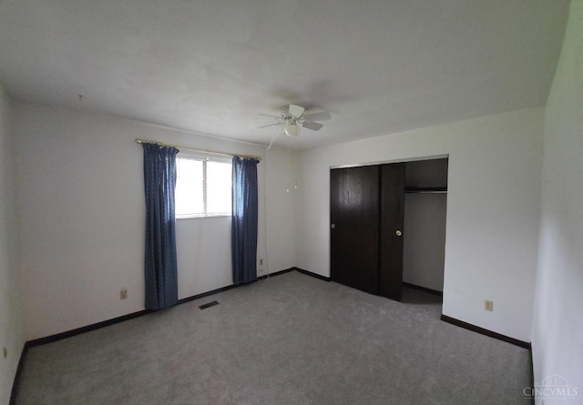 unfurnished bedroom featuring carpet, visible vents, baseboards, and a closet