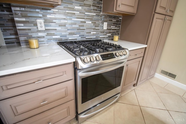 1103 Towanda Ter, Cincinnati, OH 45216 - kitchen featuring visible vents, light tile patterned flooring, stainless steel gas stove, and backsplash