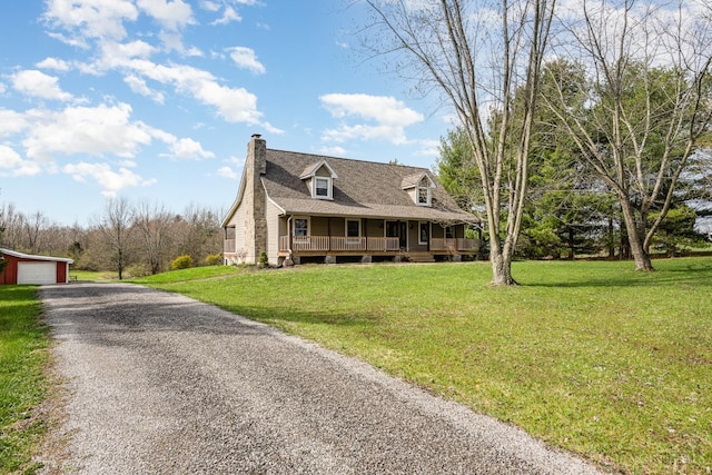 view of front of home featuring a porch, a chimney, a front lawn, and an outbuilding
