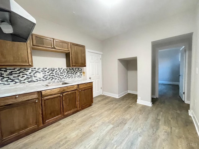 2259 Loth St, Cincinnati, OH 45219 - kitchen with a sink, light wood finished floors, backsplash, light countertops, and baseboards