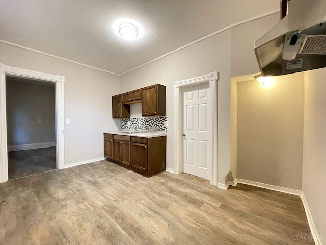 2259 Loth St, Cincinnati, OH 45219 - kitchen featuring light wood finished floors, light countertops, ventilation hood, and baseboards