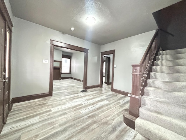 1239 Sliker Ave, Cincinnati, OH 45205 - entryway featuring stairs, baseboards, light wood-style flooring, and a textured ceiling