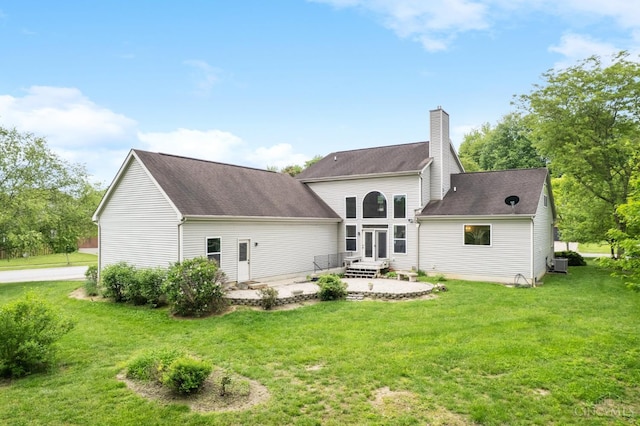 rear view of property featuring a chimney, a patio, central AC, a lawn, and entry steps