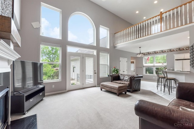 living area featuring a towering ceiling, carpet floors, baseboards, and recessed lighting