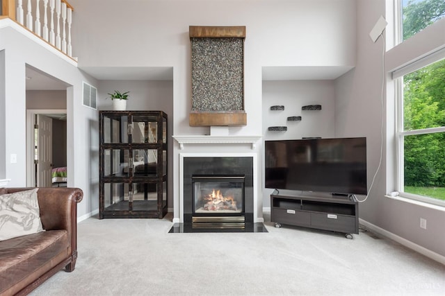 carpeted living room with a fireplace with flush hearth, plenty of natural light, and baseboards