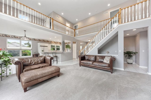 living room featuring a towering ceiling, carpet flooring, recessed lighting, baseboards, and stairs