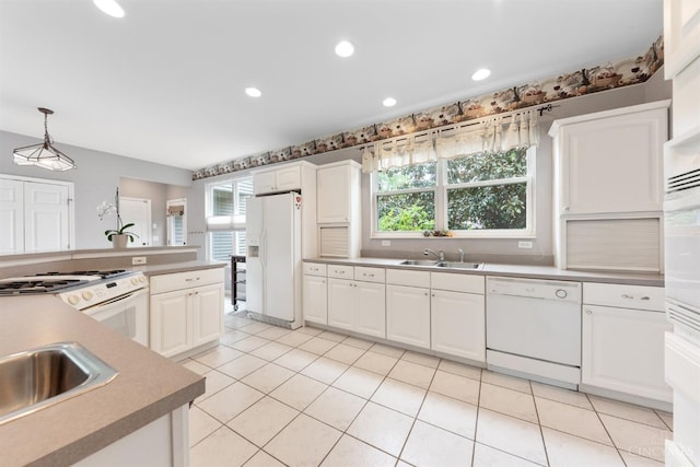 kitchen with white appliances, healthy amount of natural light, white cabinetry, and recessed lighting