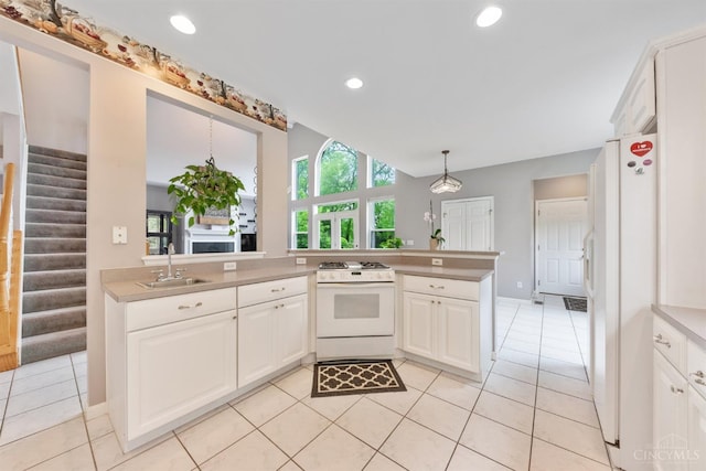 kitchen featuring white appliances, a sink, light countertops, white cabinetry, and light tile patterned floors