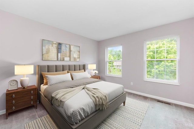 bedroom with light carpet and baseboards