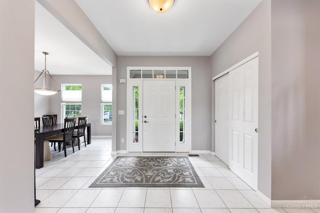 entryway with baseboards and light tile patterned flooring
