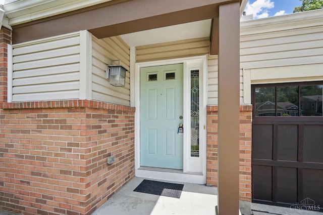 doorway to property with brick siding