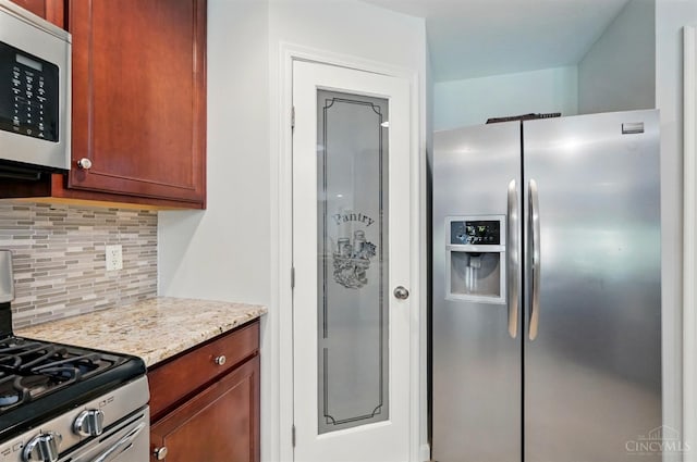 kitchen with appliances with stainless steel finishes, decorative backsplash, and light stone counters