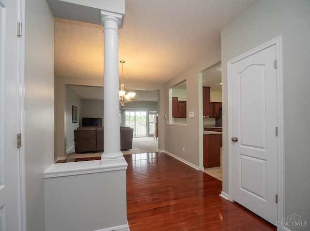 9413 Stoneybrooke, Springfield Twp, OH 45231 - hallway featuring dark wood-type flooring, ornate columns, a chandelier, and baseboards