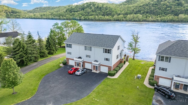 view from above of property featuring a heavily wooded area and a nearby body of water