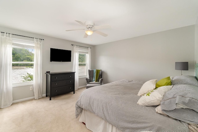 bedroom with baseboards, light carpet, and ceiling fan