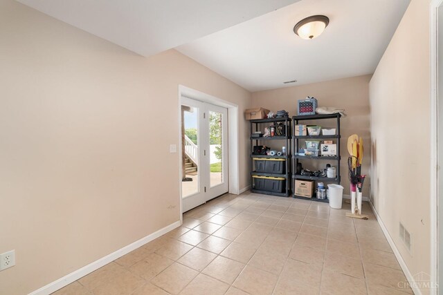 spare room featuring light tile patterned floors and baseboards