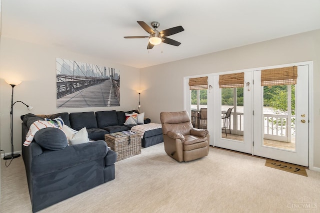 living area featuring carpet flooring and a ceiling fan