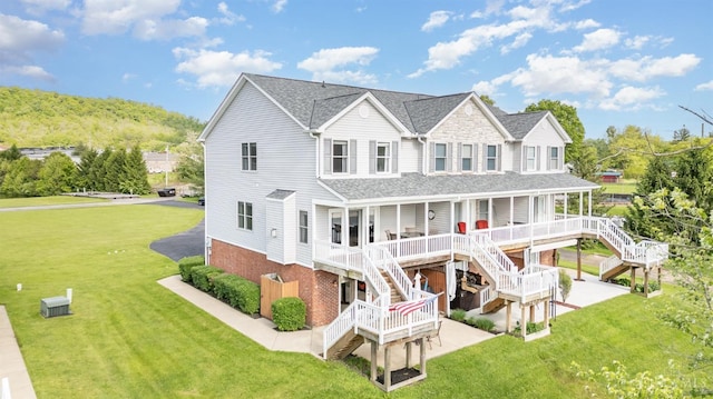 view of front of house featuring stairway, a porch, a front lawn, and roof with shingles