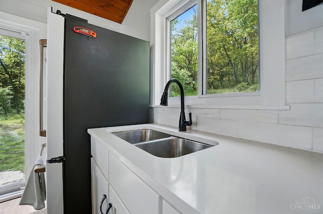 11675 New Biddinger Rd, Harrison Twp, OH 45030 - kitchen with a sink, backsplash, white cabinetry, light countertops, and freestanding refrigerator