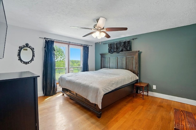 11675 New Biddinger Rd, Harrison Twp, OH 45030 - bedroom featuring baseboards, light wood-style floors, a textured ceiling, and ceiling fan